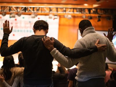 two men holding ear others hand