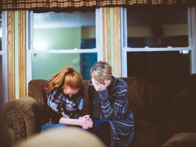 man and woman sitting on sofa in a room