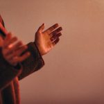 person in red sweater wearing silver ring