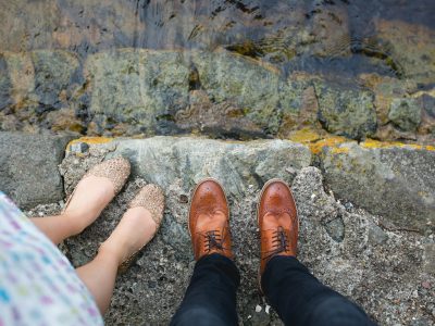 photo of woman and man standing near body of water