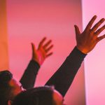 man in black long sleeve shirt raising his hand