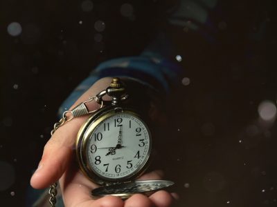 a person holding a clock in their hand