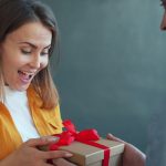Woman happily receiving a gift from man