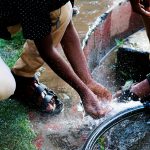 woman in black tank top and white pants sitting on water fountain