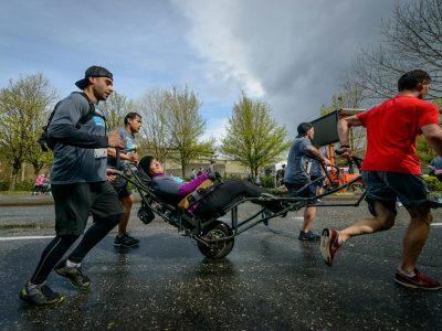 man in black jacket riding on black and red stroller