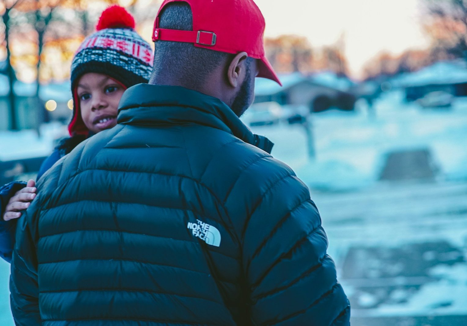 man carrying boy wearing jacket